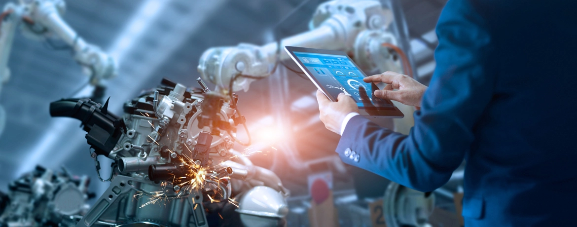 Engineer using tablet to monitor production process in a smart manufacturing environment.